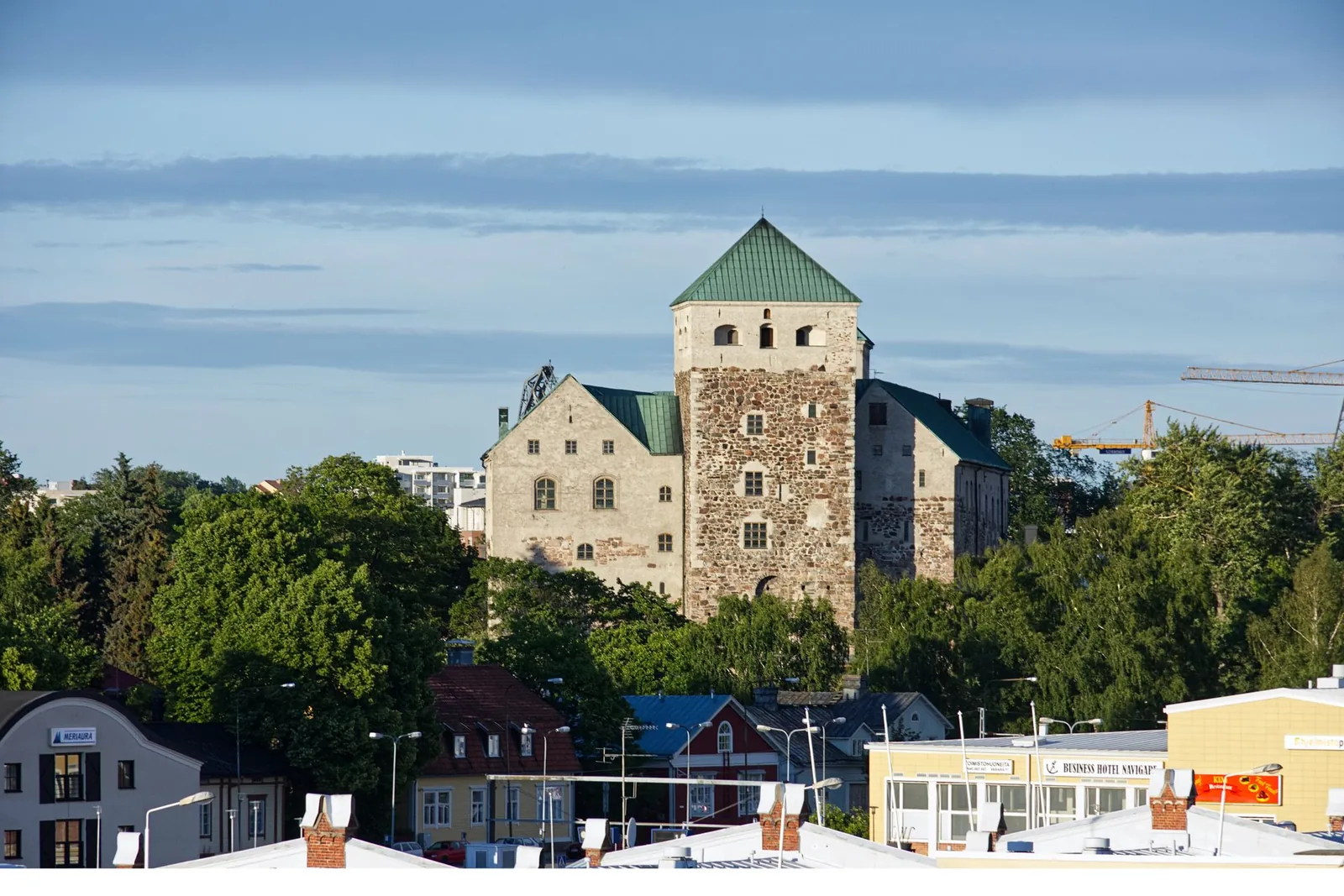 Turun linna vehreän puiston ja uudempien rakennusten keskellä