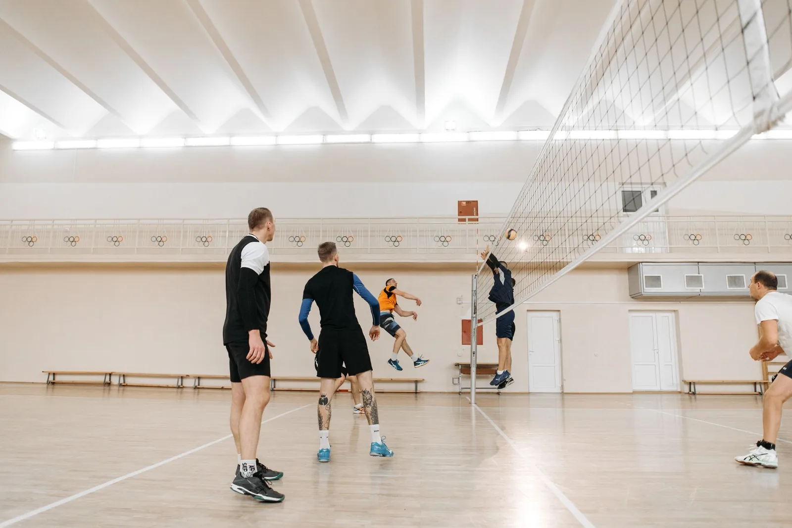 Pelaajia urheiluhallissa verkon äärellä