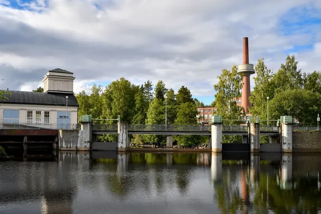 Vesivoimalaitoksen pato ja piippu heijastuvat veteen Jyväskylässä