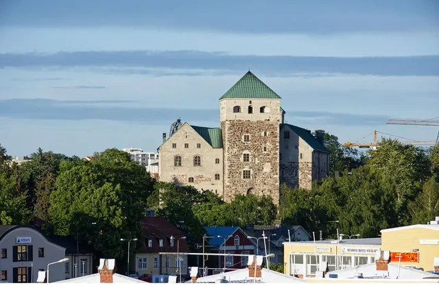 Turun linna vehreän puiston ja uudempien rakennusten keskellä