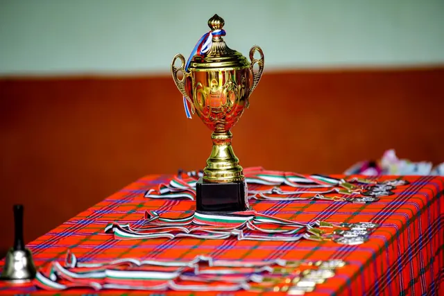 Kultainen pokaali ja mitalit pÃ¶ydÃ¤llÃ¤