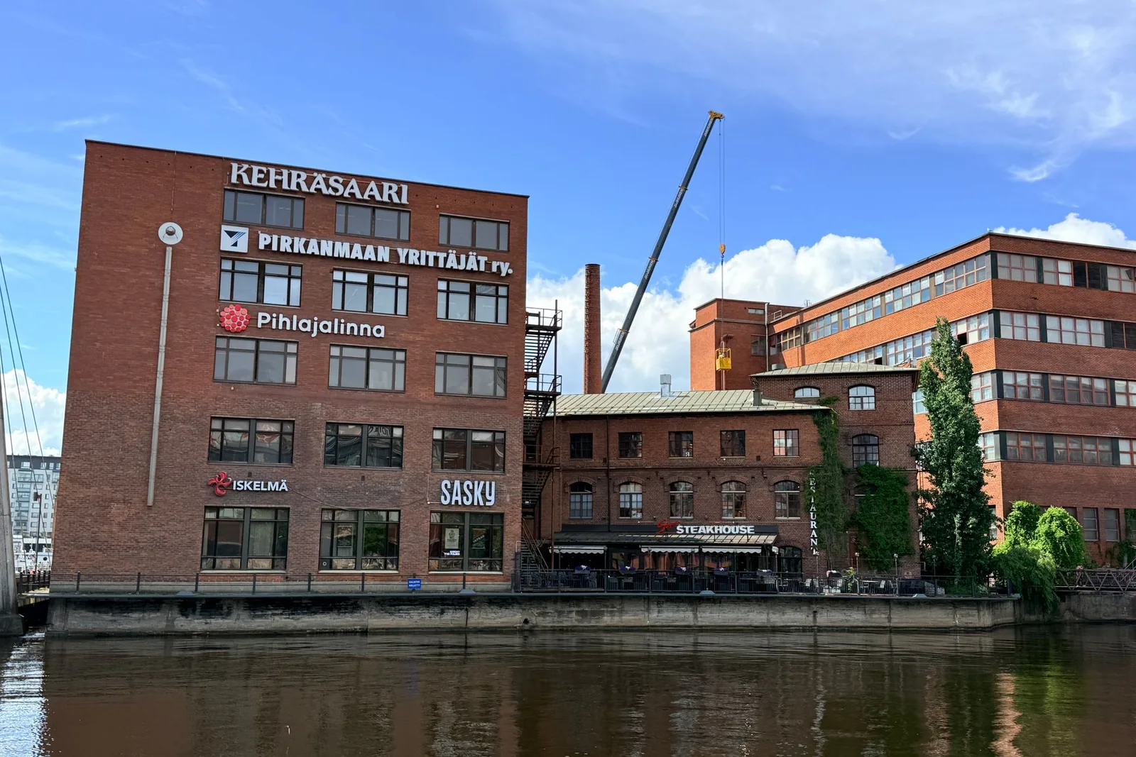 KehrÃ¤saaren punatiilirakennuksia joen rannalla Tampereella