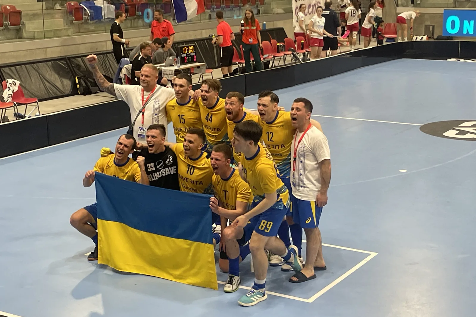 Joukkue juhlii voittoa salibandyhallin kentällä